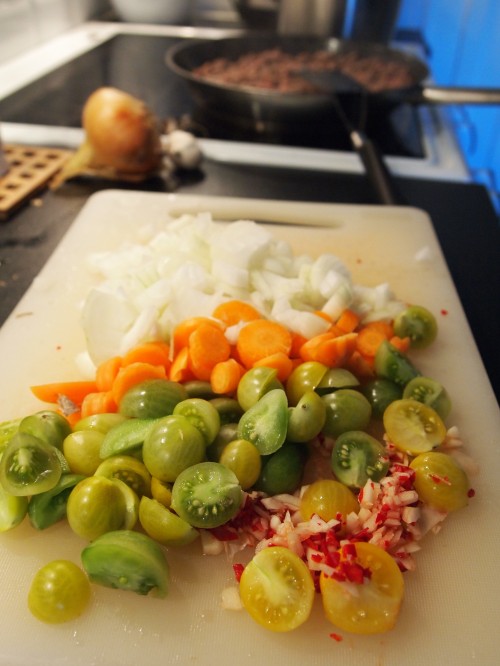 Skördemiddag med gröna körsbärstomater, lök, chili och vitlök.